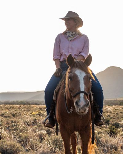 Profile image of Bee Strydom riding a chestnut horse with blaze.